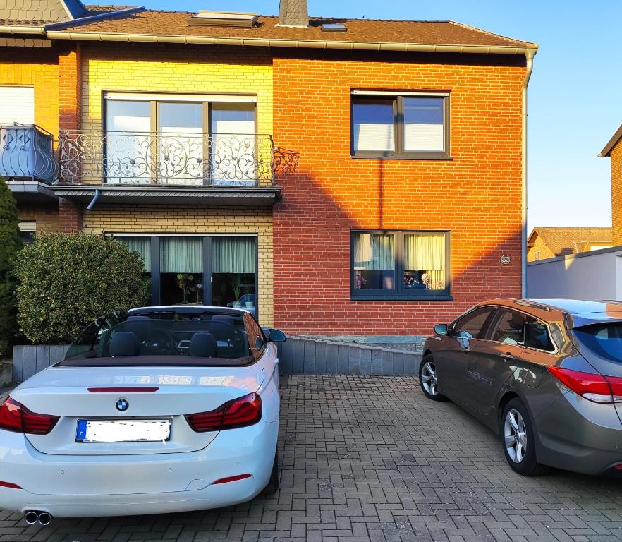 twee auto's geparkeerd voor een huis bij Casa Ilona in Düren - Eifel