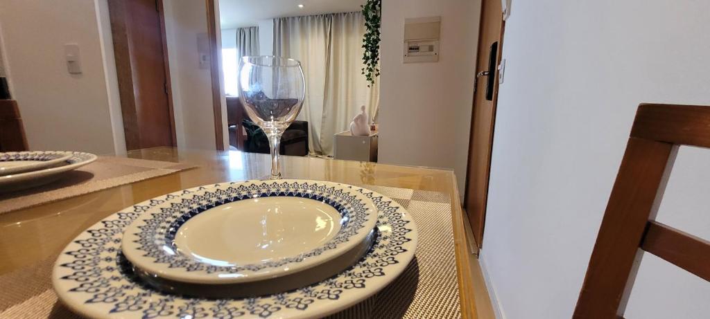 a table with a plate and a wine glass at São Paulo Flat Familia ExtraComfort TV 65" lado Sírio Libanes in Sao Paulo