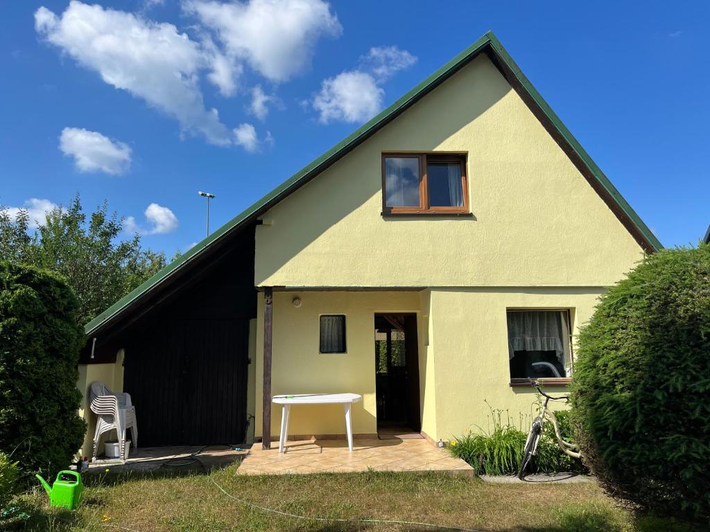 a yellow house with a table in front of it at Dom Gaja in Ińsko