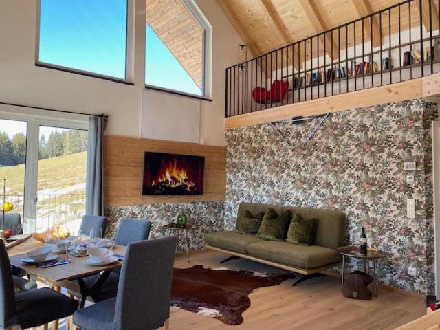 a living room with a couch and a fireplace at Hillside Retreat in Fresach