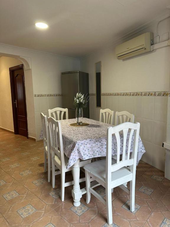 a white table with white chairs and a vase of flowers on it at Apartamento 3 habitaciones Valencia in Alboraya