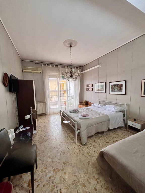 a bedroom with a large bed and a chandelier at LG Appartamento Turistico Giarre in Giarre