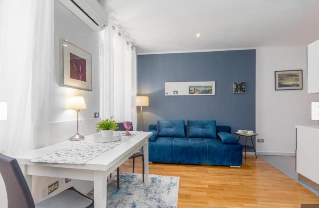 un soggiorno con un divano blu e un tavolo di Augustina Apartment a Rovigno (Rovinj)