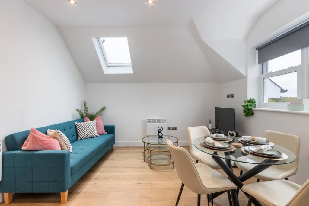 ein Wohnzimmer mit einem blauen Sofa und einem Tisch in der Unterkunft Premium 2-Bedroom Apartment, Leatherhead, Sleeps 4 in Leatherhead