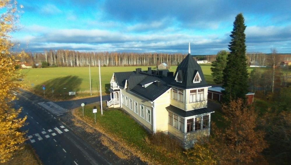 une grande maison blanche avec un toit noir dans l'établissement Wanhan Apteekin Majatalo, à Kerimäki