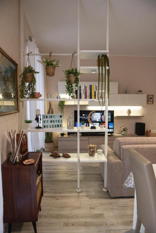 a living room with a couch and shelves with plants at Casa Lucrezia - alla Torre in Viterbo