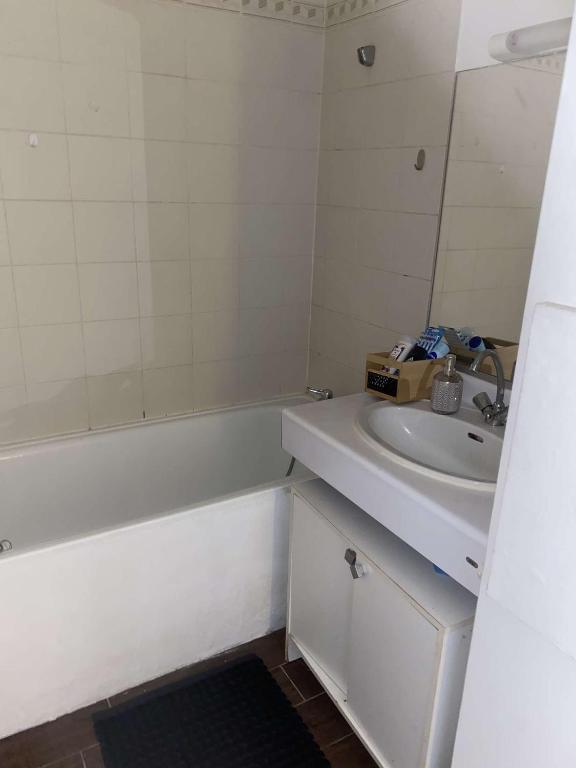 une salle de bain avec un lavabo et une baignoire et un lavabo dans l'établissement petit appartement cosy, à Noisy-le-Grand