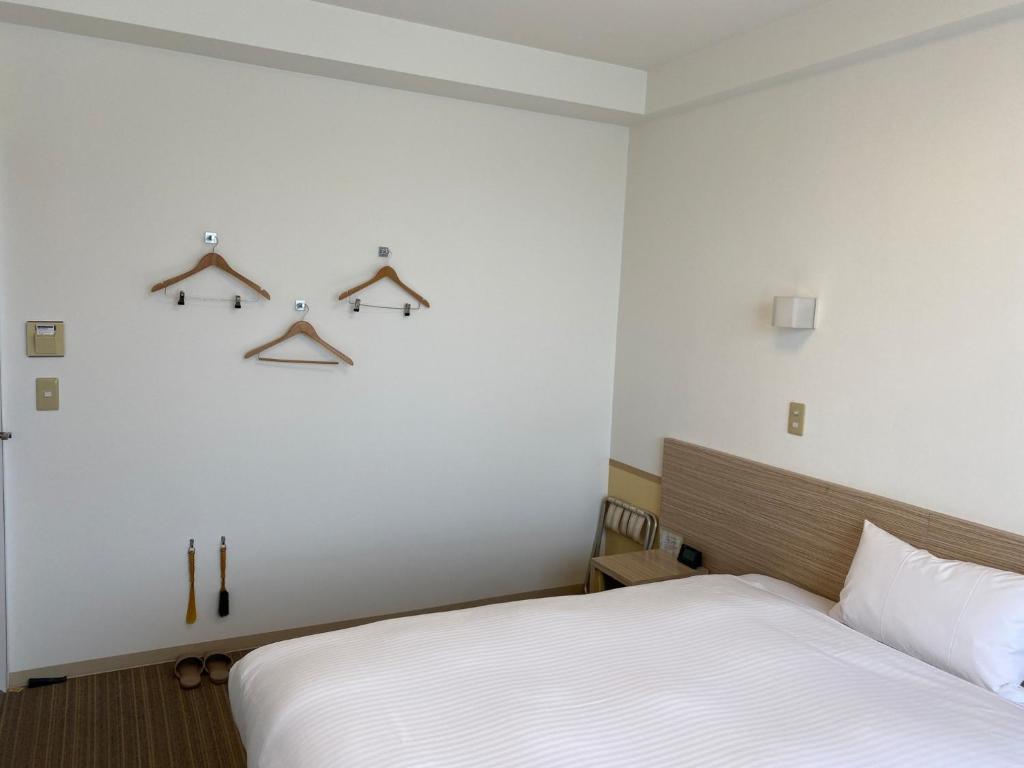 1 dormitorio con cama y perchas en la pared en Smile Hotel Shirakawa - Vacation STAY 54752v, en Nishigo