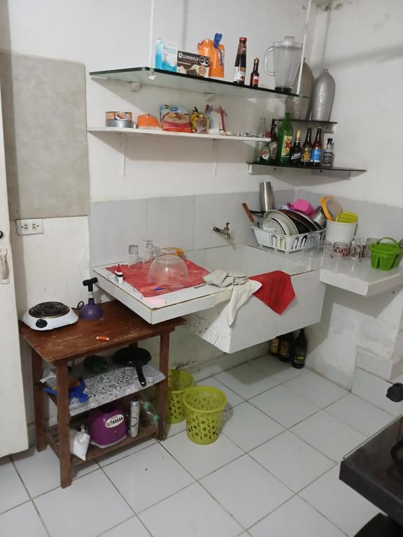 a kitchen with a sink and a table and shelves at Rhinos House in Cozumel