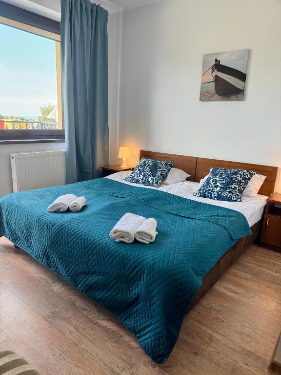 a bedroom with two towels on a bed with a window at Willa Klif &Spa in Jastrzębia Góra