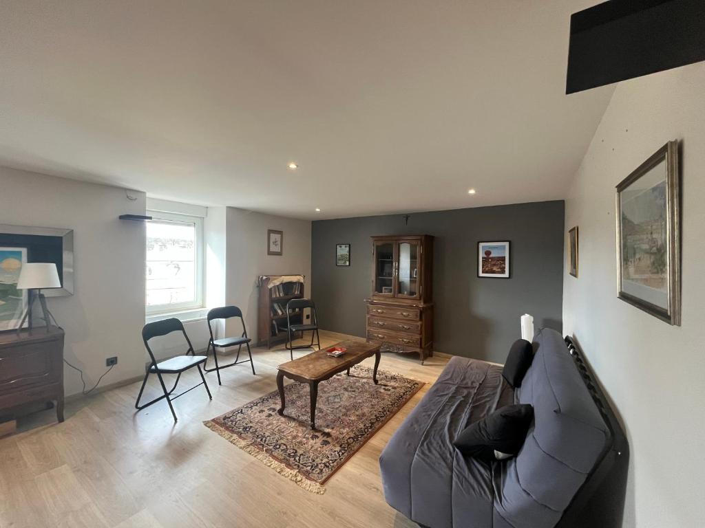 un salon avec un canapé et une table dans l'établissement L'Horizon du Beffroi, à Millau