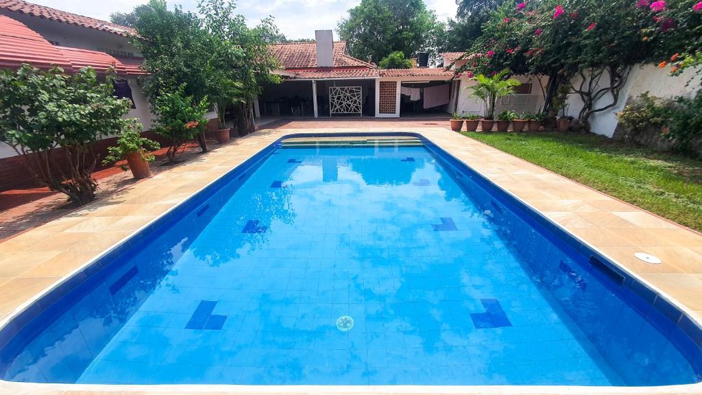 a large blue swimming pool in front of a house at Quinta San Miguel Ricaurte in Ricaurte