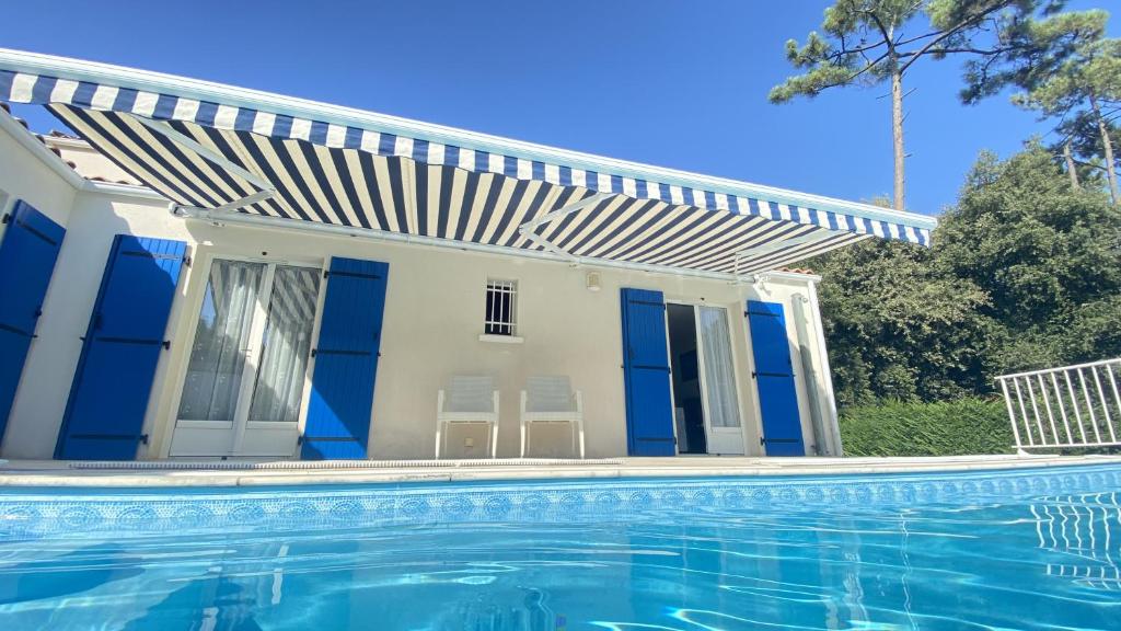 une maison avec une piscine devant une maison dans l'établissement Coastal bliss, à Grand-Village-Plage
