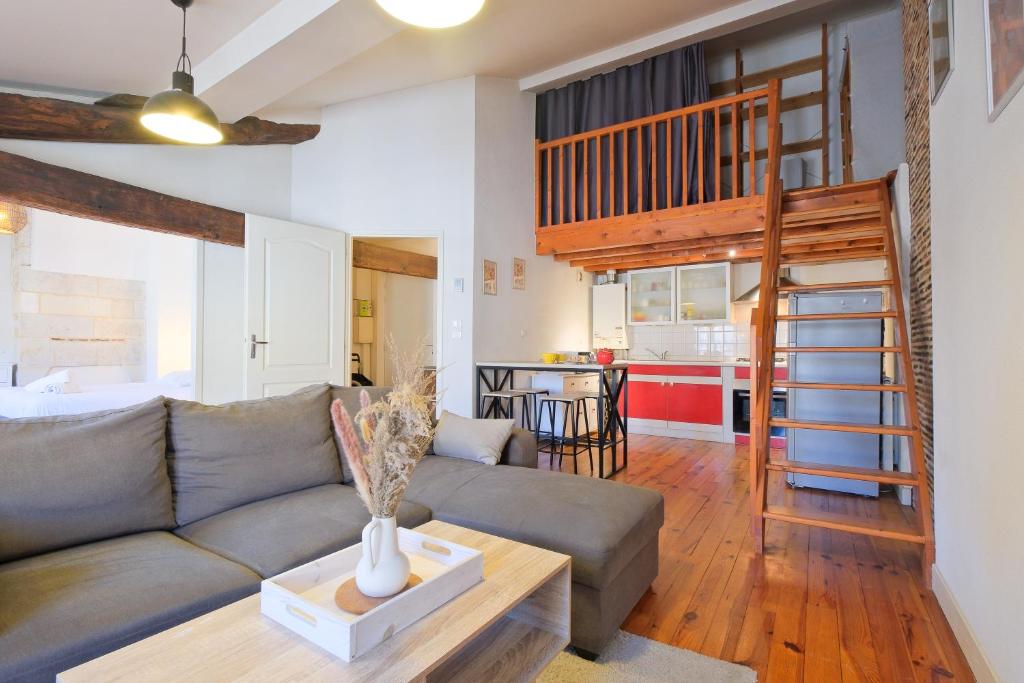 un salon avec un canapé et une table dans l'établissement le cocon de Taillefer, à Périgueux