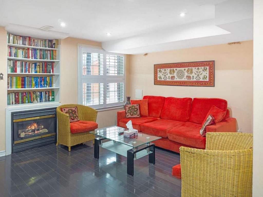 a living room with a red couch and a fireplace at Private - Spacious with Jacuzzi and Great Location in Mississauga