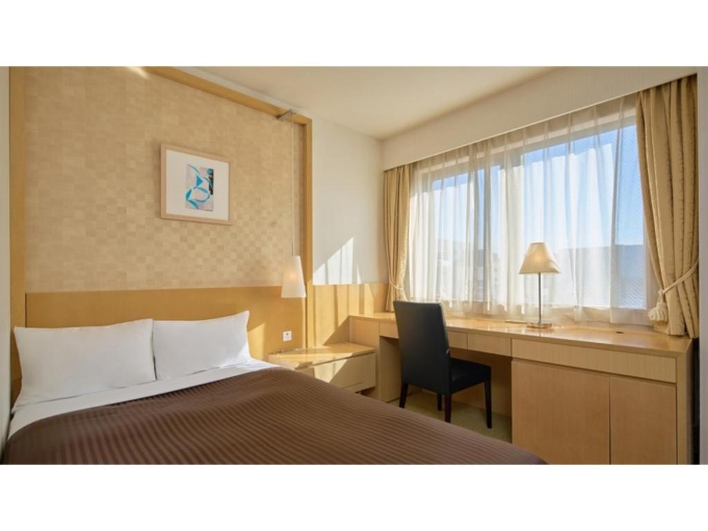ein Hotelzimmer mit einem Bett, einem Schreibtisch und einem Fenster in der Unterkunft The OneFive Tokyo Kameido - Vacation STAY 64595v in Tokio
