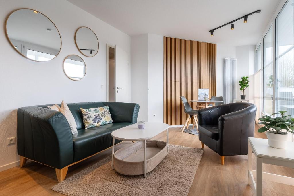 un salon avec un canapé et deux chaises dans l'établissement Ferienwohnung Four Twee – Ihr gemütlicher Rückzugsort in SPO, à Sankt Peter-Ording