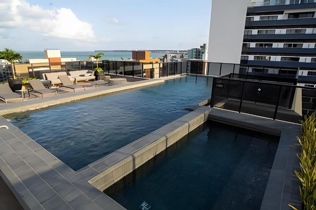 a swimming pool on the roof of a building at Flat novo, moderno e super bem localizado in Tambaú