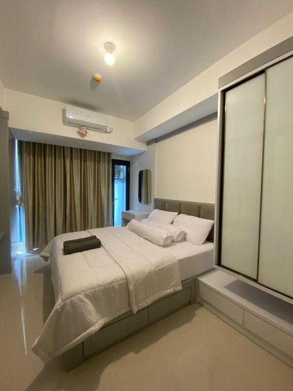 a bedroom with a large bed and a window at Pollux Studio Apartment 1618 Free Wifi & Netflix in Jodoh