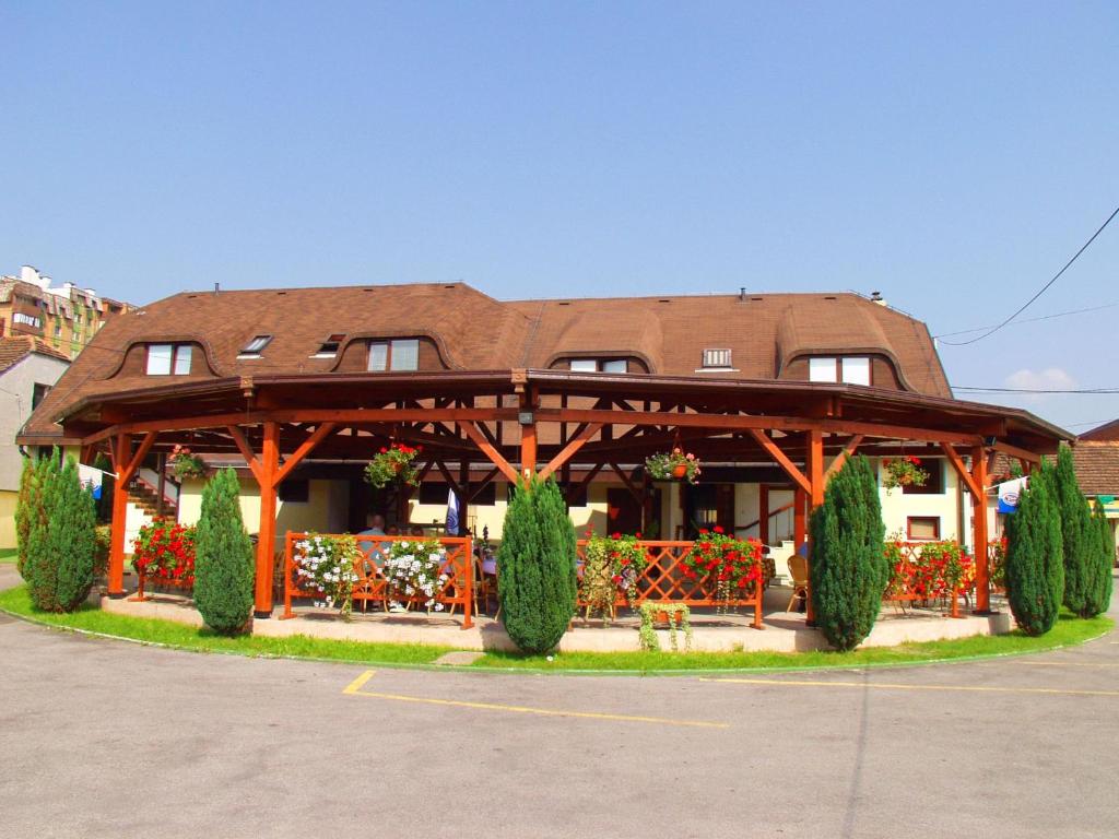 a building with a pavilion with bushes and trees at B&B Garestin in Varaždin