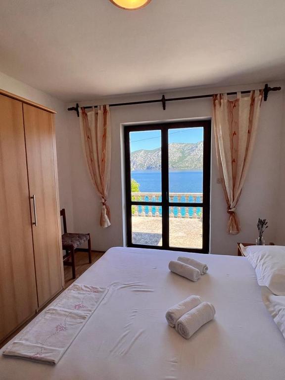 a bedroom with a large bed with two towels on it at Beachfront Apartment Mery, Kneže in Račišće