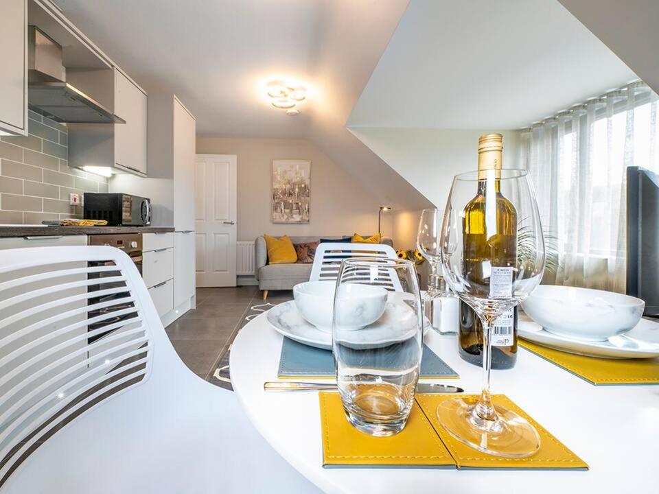 a kitchen with a table with wine glasses on it at Belfast city stylish spacious apartment great location free parking in Belfast