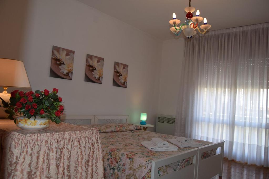 スピネーアにあるCasa Vacanza e per lavoro Elena e Carlaの花瓶が飾られたベッド付きのベッドルーム1室