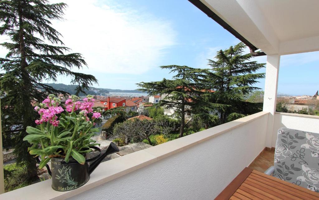 eine Vase aus Blumen auf einem Balkon mit Aussicht in der Unterkunft Apartments San Francesco in Rovinj