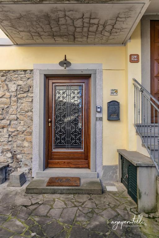 una porta in legno con un cancello di metallo su una casa di La Terrazza di Tranci a Calice al Cornoviglio