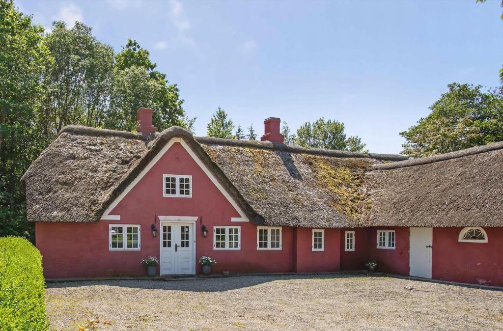 a red house with a thatched roof at Cozy Holiday Apartment On Rømø in Vesterhede