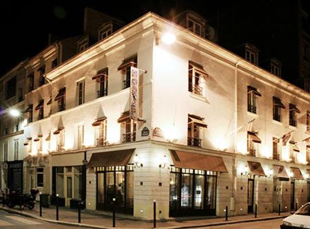 un gran edificio blanco en una calle por la noche en Aloha Hostel Eiffel Tower by Hiphophostels en París