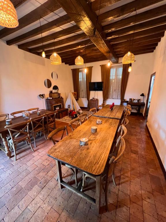 Habitación grande con mesas y sillas de madera. en Maison Henriette, en Léré