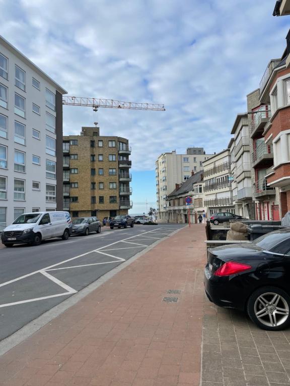 een straat met auto's aan de kant van de weg bij Zonnige studio Mermoz Koksijde-Bad in Koksijde