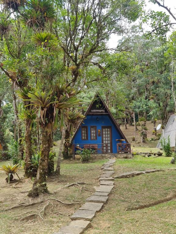 a blue house in the middle of a forest at A Luz Azul - Pousada e Gastronomia in Bananal