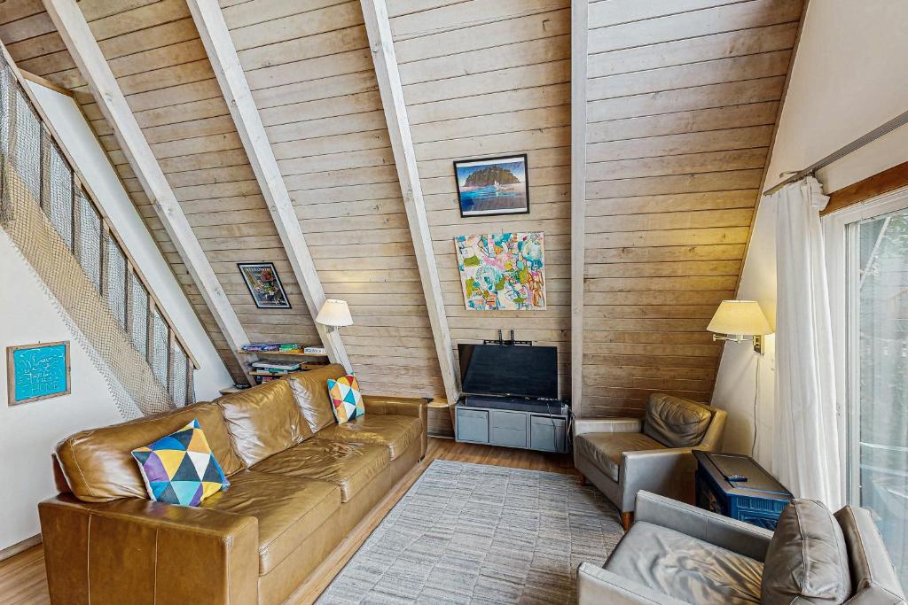 un soggiorno con un divano e una televisione di A-Frame Hideaway a Neskowin