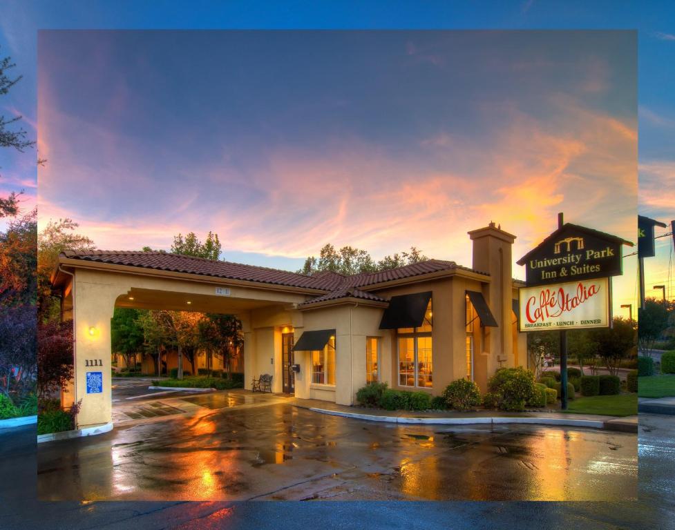 ein Hotel mit Schild auf einem Parkplatz in der Unterkunft University Park Inn & Suites in Davis