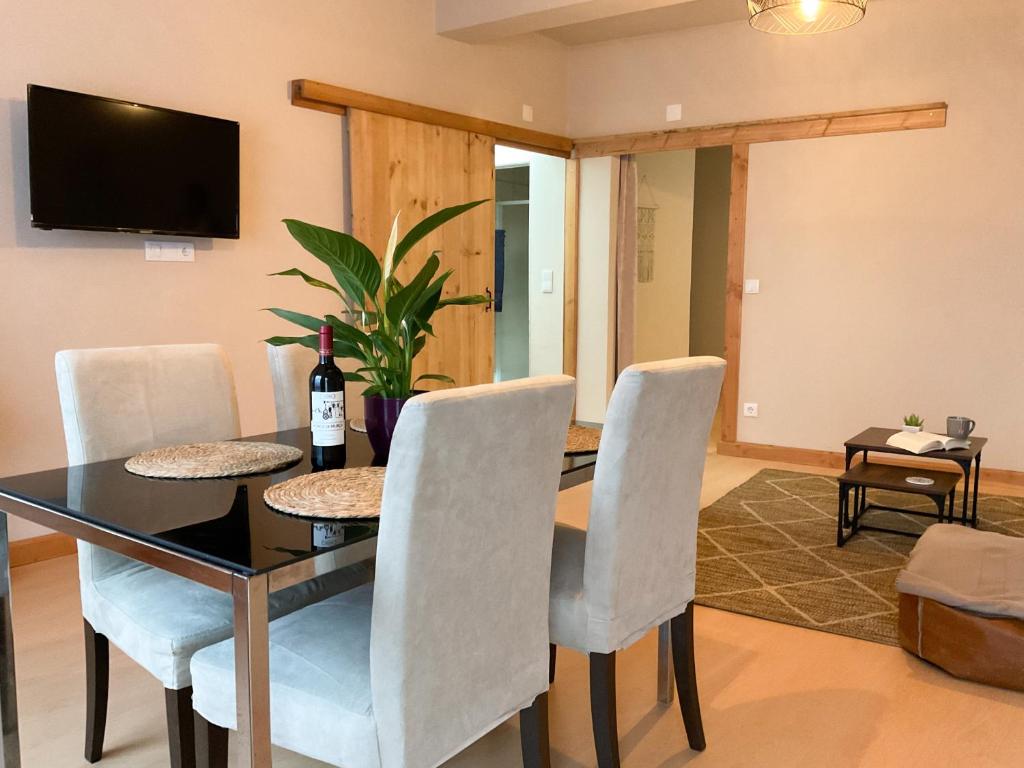 a dining room with a table and chairs and a television at Casa Pinheiro in Pinheiro de Coja
