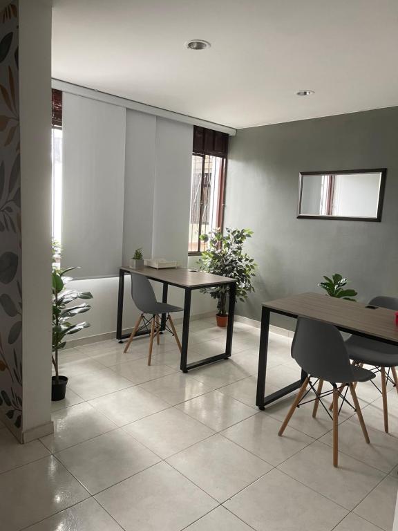 ein Wohnzimmer mit 2 Tischen, Stühlen und Pflanzen in der Unterkunft Apartamento moderno cerca al aeropuerto in Neiva