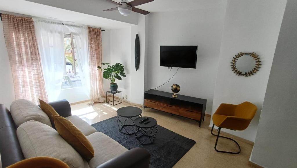 een woonkamer met een bank en een flatscreen-tv bij Apartamento Grau de Gandía in Gandía