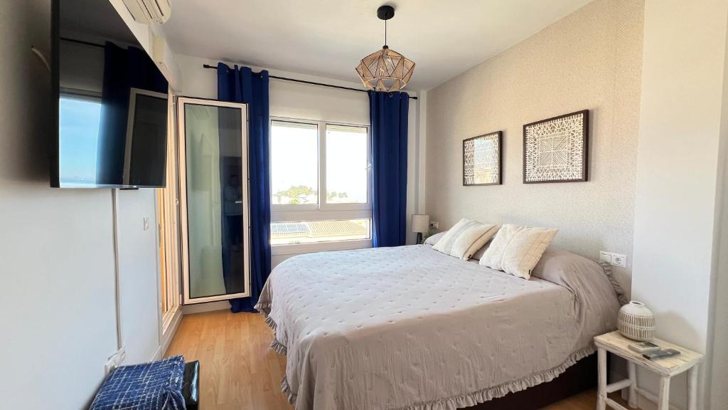 a bedroom with a bed and a large window at MAR AZUL Playa y Piscina 80 metros de la playa in Roquetas de Mar