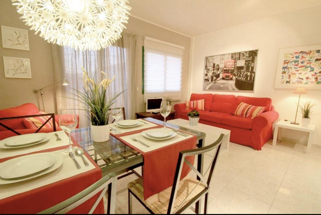 un soggiorno con tavolo e divano rosso di Departamento Corriquia a Playa Blanca