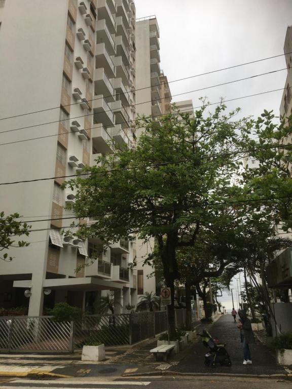 a city street with a tall apartment building at Vista ao Mar Praia Pitangueiras Servico de praia Garagem in Guarujá