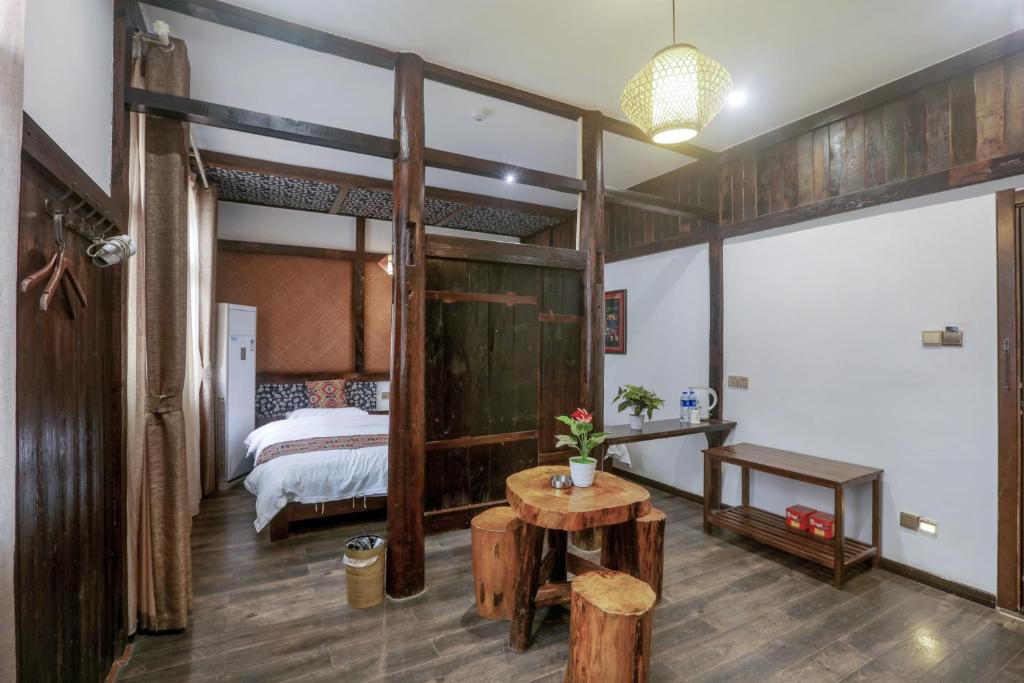 a bedroom with a bed and a table in a room at 张家界畔山驿栈 in Zhangjiajie