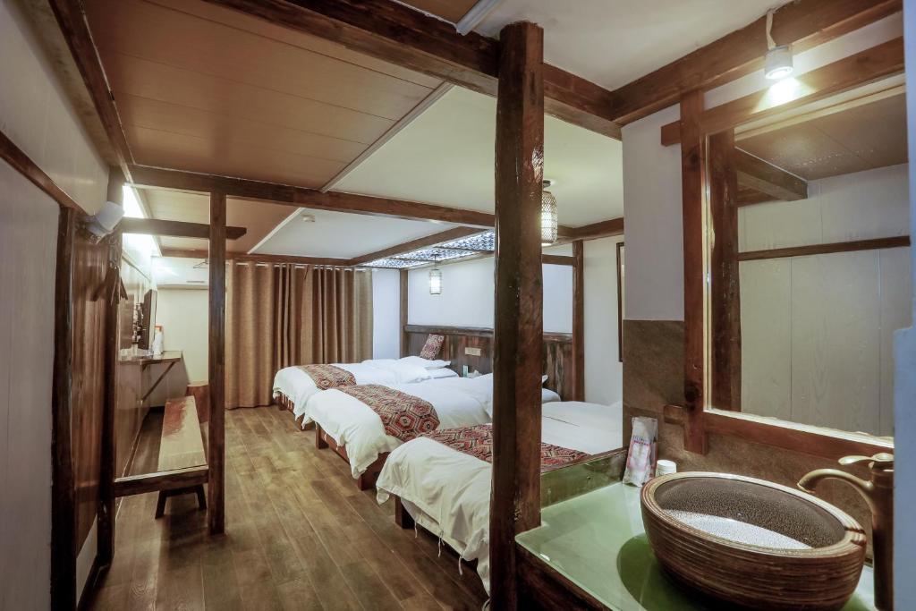 a room with three beds and a sink in it at 张家界畔山驿栈 in Zhangjiajie