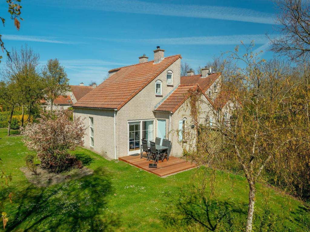 a large white house with a wooden deck at Holiday Home Brouwershaven near Grevelingenmeer in Brouwershaven