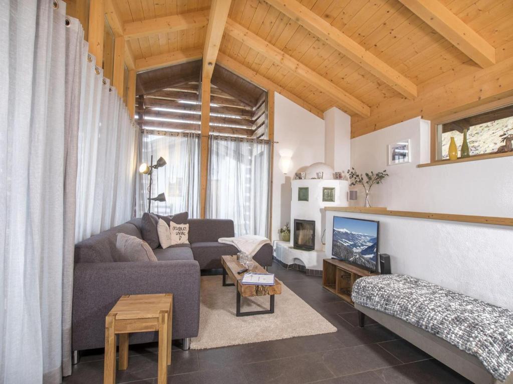a living room with a couch and a tv at Chalet in Königsleiten near Zillertal Ski Area in Wald im Pinzgau