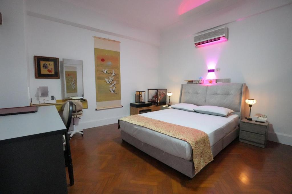 um quarto com uma cama grande com uma luz rosa em Japan Comfort Lifestyle Osaka em Ipoh