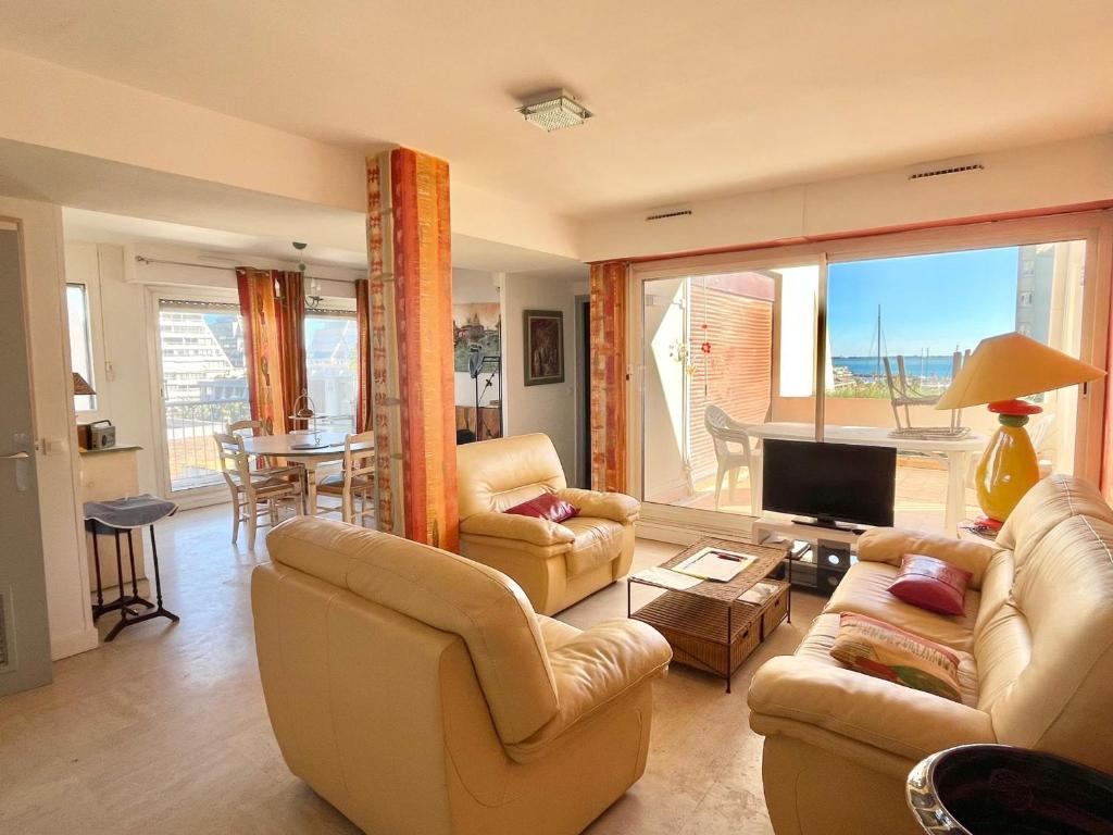 un salon avec un canapé, des chaises et une télévision dans l'établissement Charmant P3 à La Grande Motte, proche plage - FR-1-716-79, à La Grande Motte