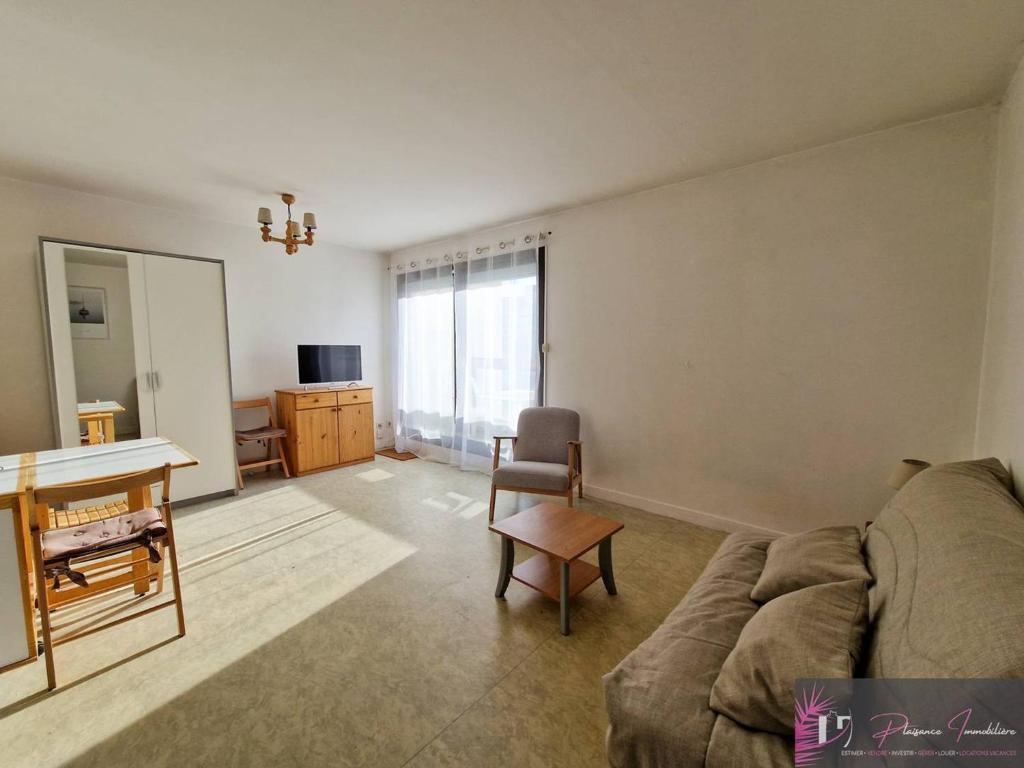 un salon avec un canapé et une table dans l'établissement Studio à La Rochelle avec piscine, proche plage - FR-1-825-22, à La Rochelle