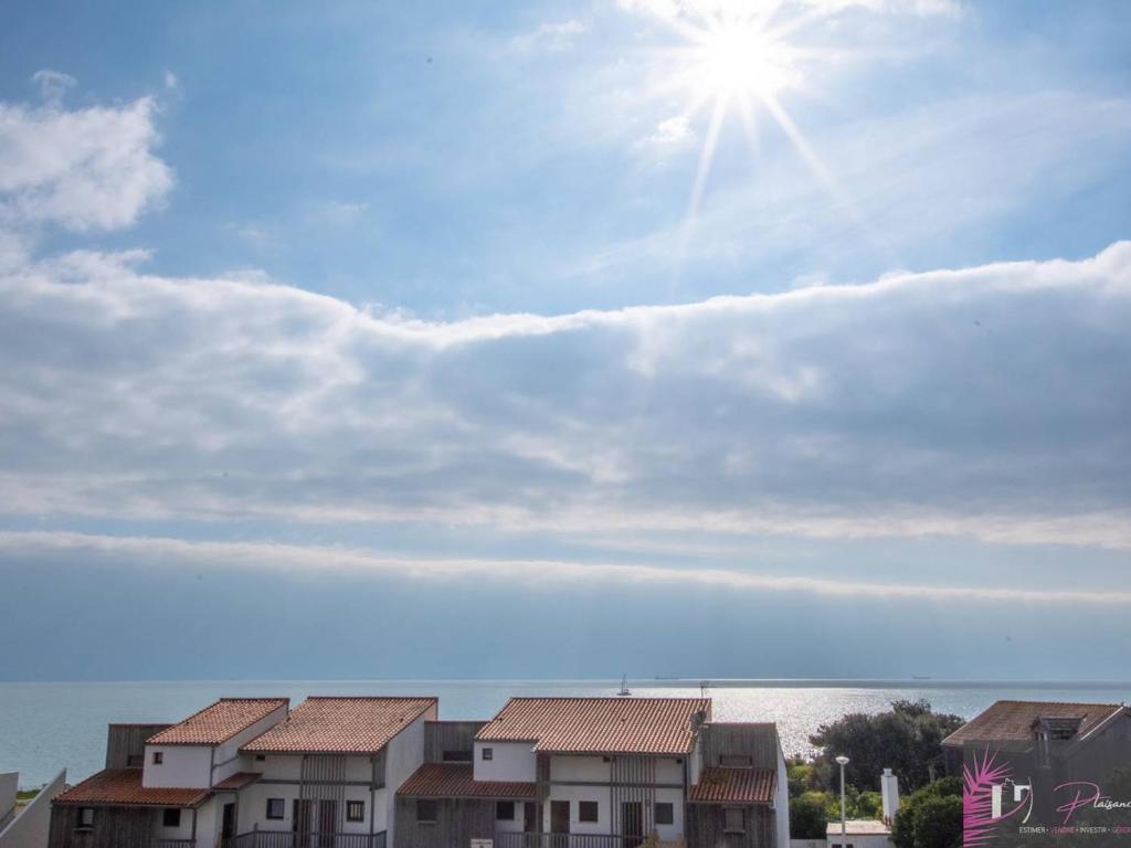 Un ciel au soleil, quelques maisons et l'eau dans l'établissement Appartement 4-6 personnes avec balcon vue mer et parking - FR-1-825-10, à La Rochelle